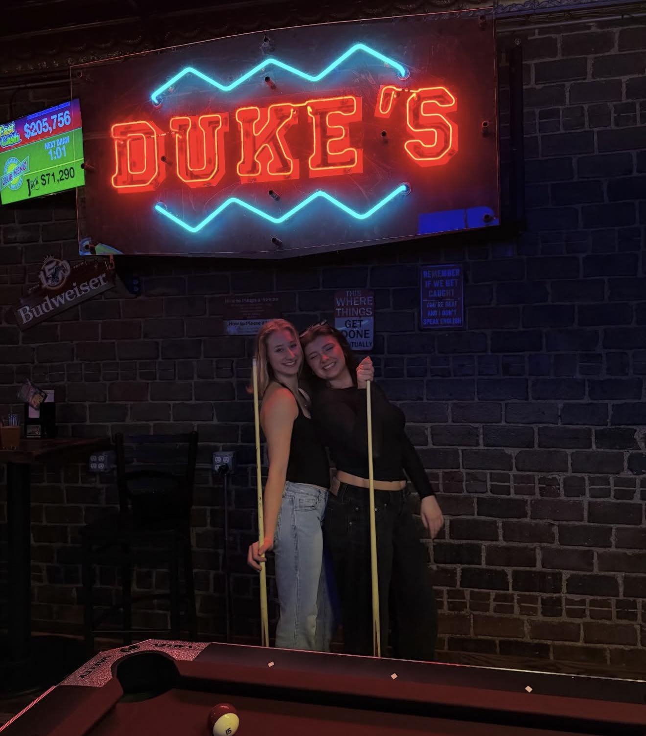 Two guests playing pool at Duke's
